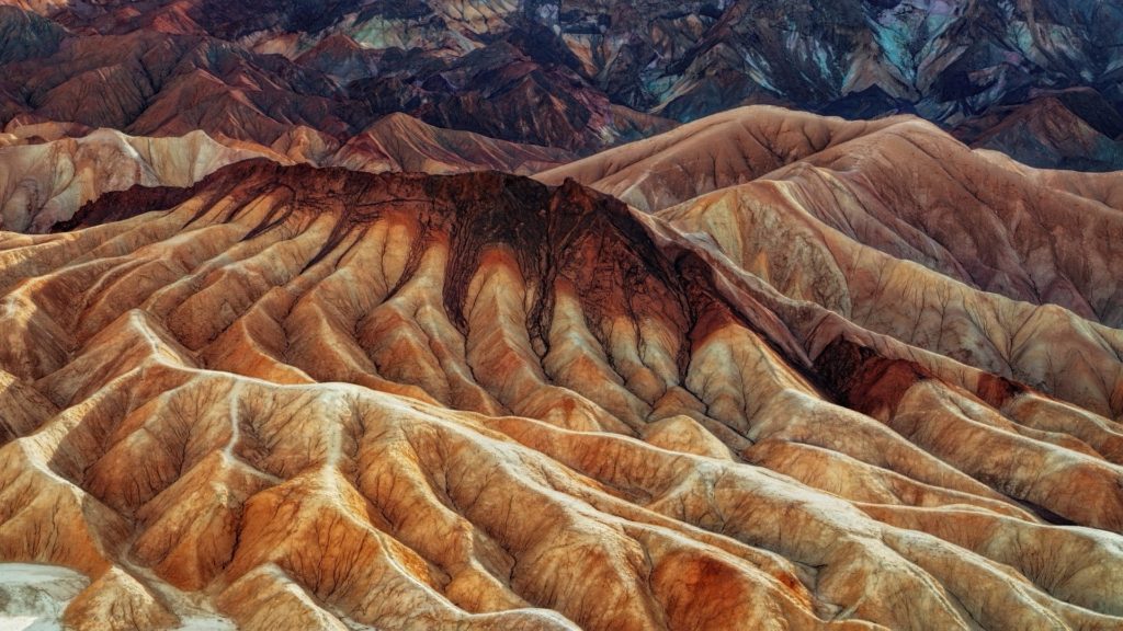 The multi-colored hills are from volcanic and sedimentary rock.