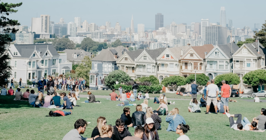 Picnic: skyline of san fransico and people sitting in groups on the gras
