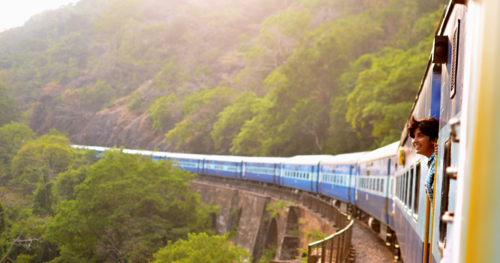 train in asia on rail with beautiful landscape and a human who's looking out of the train