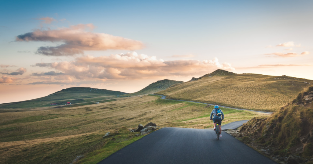 Biker rides his bike in beautiful landscape with hills