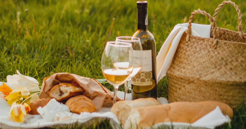 picture of a romantic picnic with wine and baguette as a perfect gift for traveler