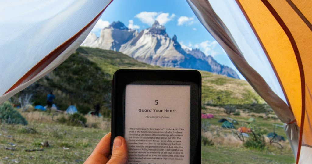 reading on a ebook reader in a tent in the mountains