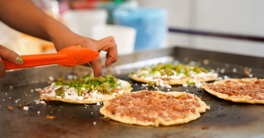Street Food Safety Tips - Venture to the vibrant Coyoacán neighborhood and savor the famed Tlayudas, akin to "Mexican pizzas." Amidst the lively street stalls, the careful preparation guarantees a delicious experience without compromising on safety.