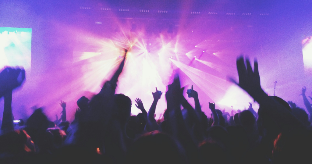 crowd cheering on a live concert