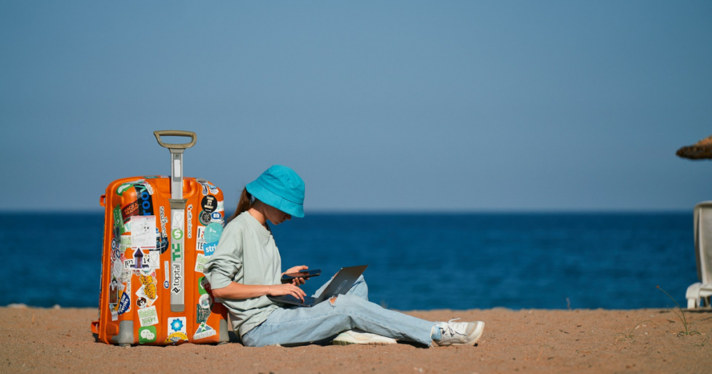 sitting on the beach with luggage and laptop